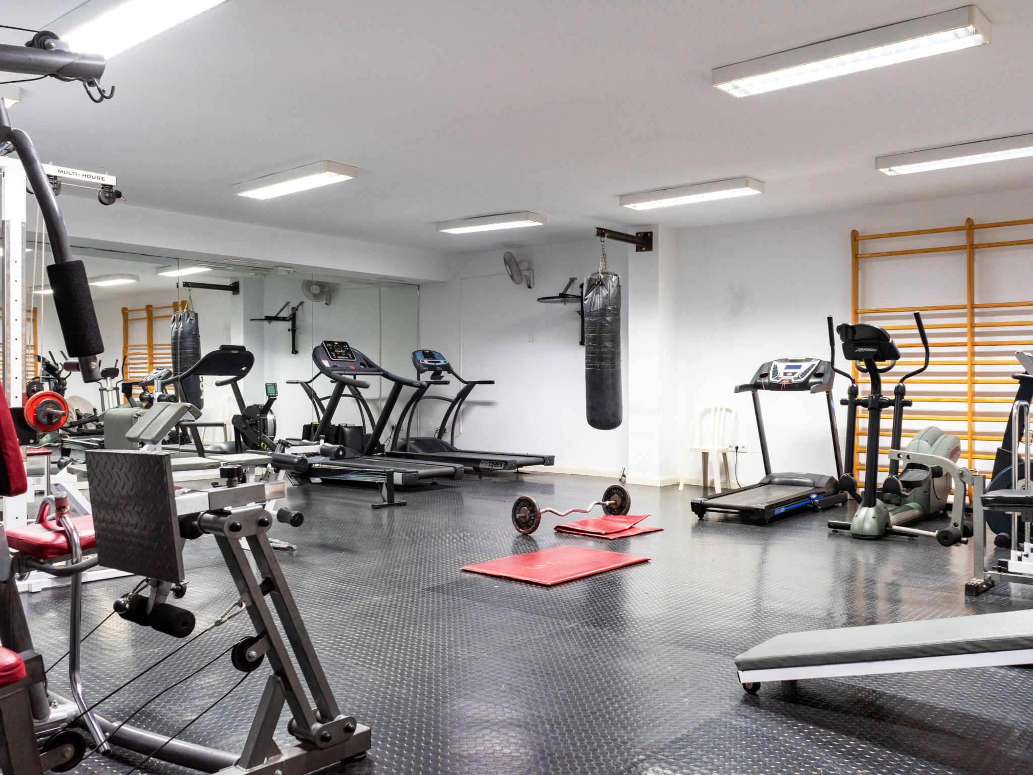 A gym with treadmills, weight machines, and a punching bag.