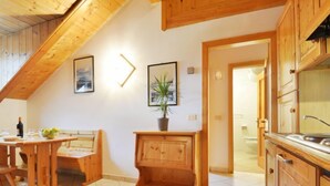 A wooden interior with a dining area, kitchen, and a staircase. - Villa Placidia Apt 32 by Interhome (Canazei)