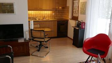 Een koelkast, een oven, kookgerei, borden en bestek