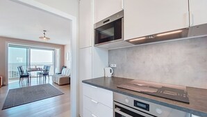 Een moderne keuken met witte kasten, een roestvrijstalen afzuigkap en een inbouwoven.