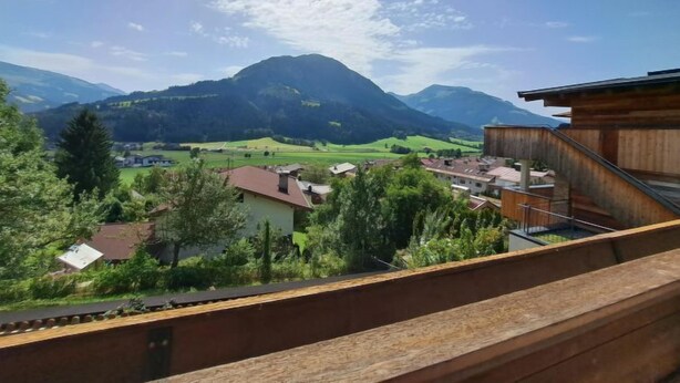 A view from a balcony overlooking a mountainous landscape with houses and greenery. - Apartment Straif by Interhome (Kirchberg in Tirol)