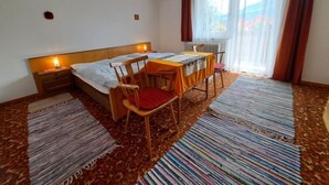 A hotel room with a bed, a table, two chairs, a lamp, and a window with curtains. - Apartment Straif by Interhome (Kirchberg in Tirol)