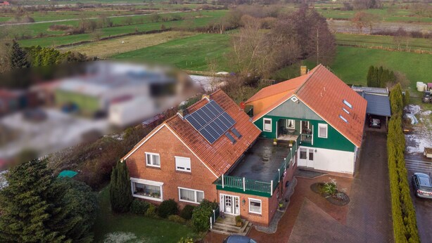 A house with a solar panel, a garage, and a driveway.