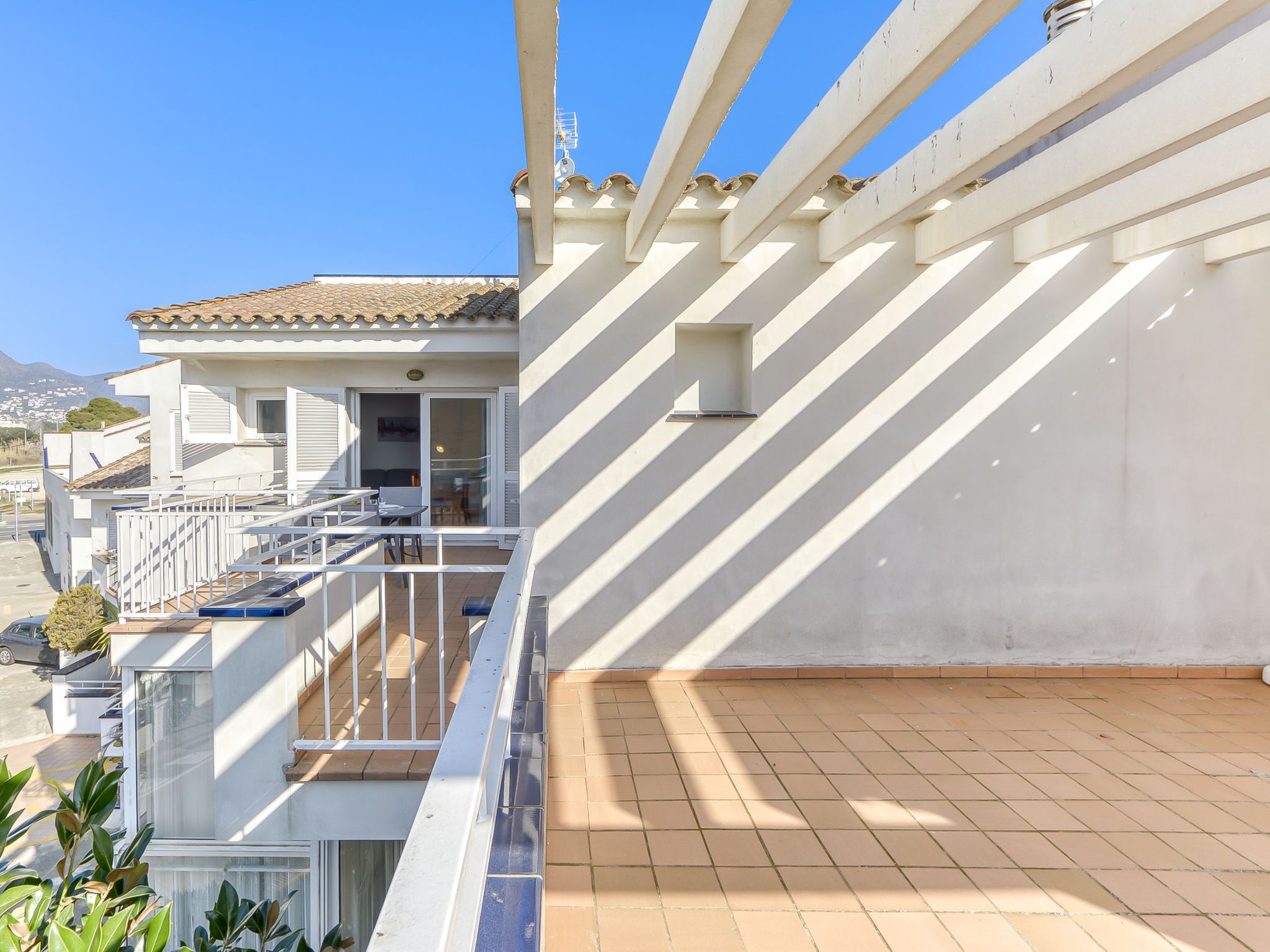 Un balcon doté d’un sol carrelé et d’une balustrade blanche.