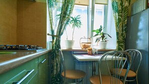 Une cuisine avec une fenêtre, deux chaises et des plantes en pot.
