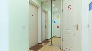 A hallway with a glass door, a white door with a no-smoking sign, and a blue window. - Home-Hotel Metropolita Sheptitskogo 1A (Kyiv)