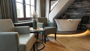 A modern interior with a reception desk, seating area, and a stone wall. - Altstadt-Hotel (Freiberg)