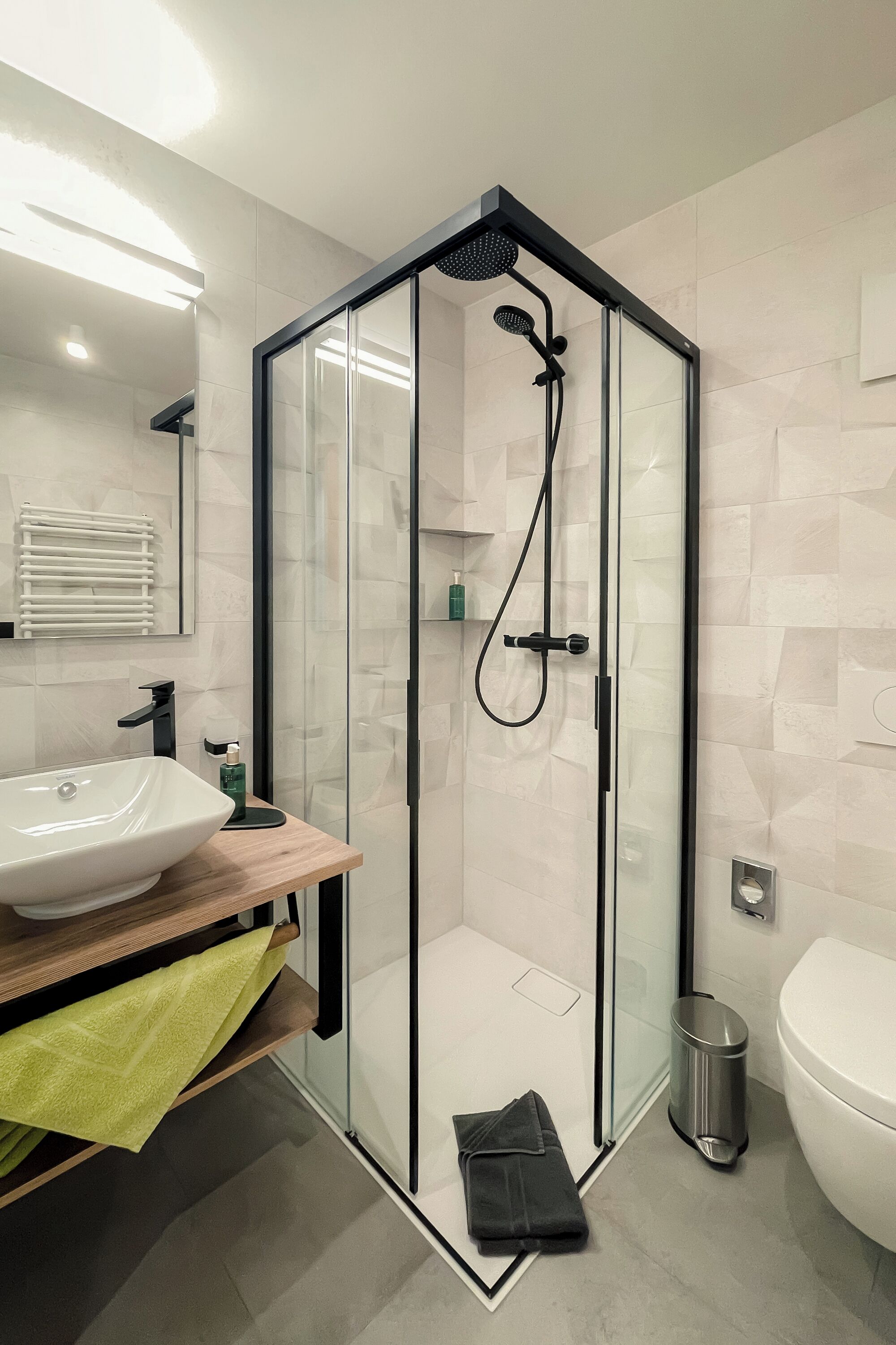 Un baño moderno con ducha de vidrio, un lavabo e inodoro.