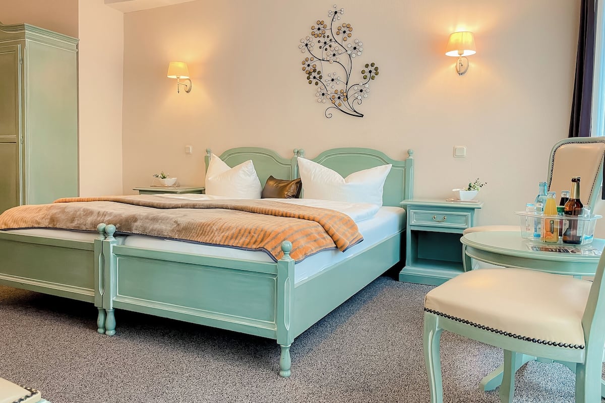 A bedroom with a bed, nightstands, a chair, and a dresser.