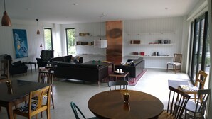 A modern living room with a black sofa, a round wooden table, and a bookshelf filled with books. - Elisetorp (Kivik)