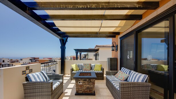 A balcony with wicker furniture, a stone table, and a view of the sea. - ‘Casa Verde’ in Cabo San Lucas -  3 Mi to Marina! (Cabo San Lucas)
