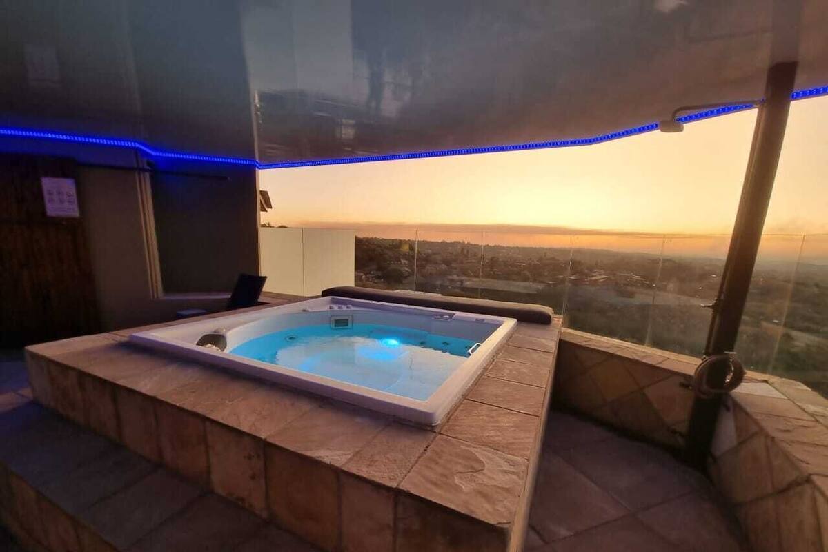 Een bubbelbad met uitzicht op de stadshemel bij zonsondergang.