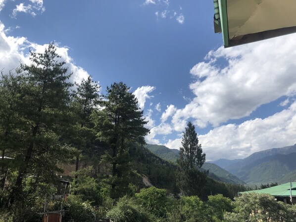 A mountainous landscape with dense forests and a clear sky.
