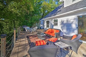 Une terrasse couverte, aménagée avec des meubles en osier, une table et des chaises.