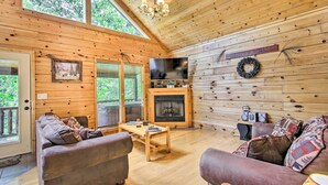 A cozy cabin interior with a wooden interior, a fireplace, a television, and a comfortable seating area. - Cabin w/ Hot Tub & Deck ~ 7 Mi to Pigeon Forge! (Sevierville)
