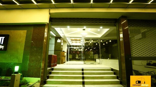 A modern hotel lobby with a staircase leading to the upper floors, glass doors, and a reception area. - The Alina Hotel & Suites (Chittagong)