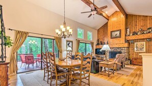 Un intérieur en bois comprenant une table à manger, des chaises, un lustre et une cheminée.