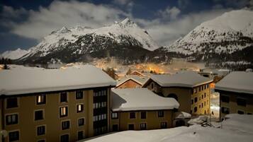Un paysage montagneux enneigé, avec des bâtiments au premier plan.
