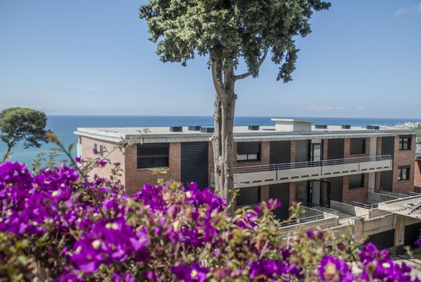 A modern building with a flat roof and large windows, overlooking a body of water. - Santa Romana (Caldes d'Estrac)