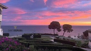 Un jardín ajardinado con vistas al mar y un edificio con el texto "SANTAROMANA".