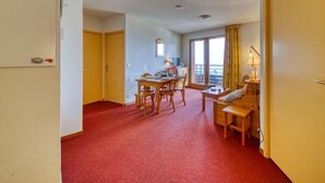 A hotel room with a dining area, a sofa, and a window with curtains. - Bâtiment A by Interhome (Le Corbier)