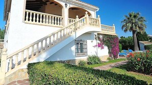 A two-story building with a white facade, a balcony with a balustrade, and a staircase leading to the upper floor. - Portichol by Interhome (Jávea)