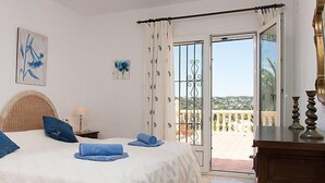 A bedroom with a bed, a nightstand, a lamp, and a view of the outside balcony. - Portichol by Interhome (Jávea)