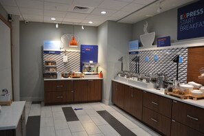 A modern breakfast area with a bakery counter, coffee station, and a sign for Express Start Breakfast.