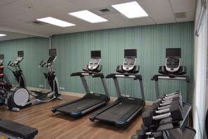 A fitness center with treadmills, elliptical machines, and a rowing machine.