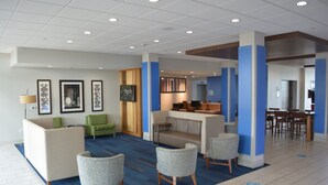Un hall d’entrée avec des espaces d’attente, un comptoir de réception et un coin repas.