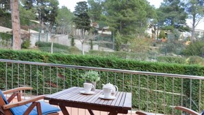 A wooden table with two chairs on a balcony, a potted plant, and a teapot on the table. - Escorxador by Interhome (L'Escala)