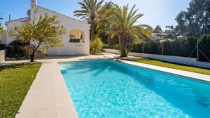 A swimming pool with a white building in the background.