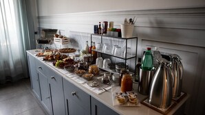 Monipuolinen buffetpöytä, jossa on tarjolla erilaisia ruokia, lisukkeita ja juomia.