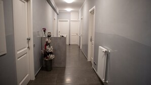 Kapea käytävä, jossa on valkoiset ovet ja oikealla puolella patteri.