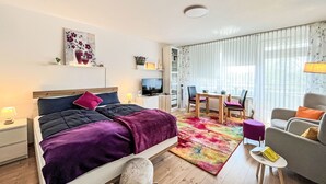 A modern hotel room with a bed, a desk, a chair, and a sofa. - Flieder (A110) by Interhome (Lahnstein (Koblenz))