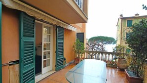 A glass table on a wooden deck with a view of the sea. - Francesca by Interhome (Camogli)