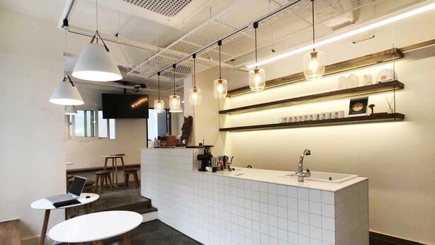 Una cocina moderna con una isla central, iluminación colgante y un salpicadero de azulejos.