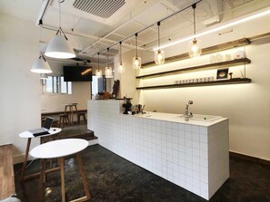 A modern kitchen with a central island, pendant lighting, and a tiled backsplash. - Seoul Cube Itaewon - Hostel (Seoul)