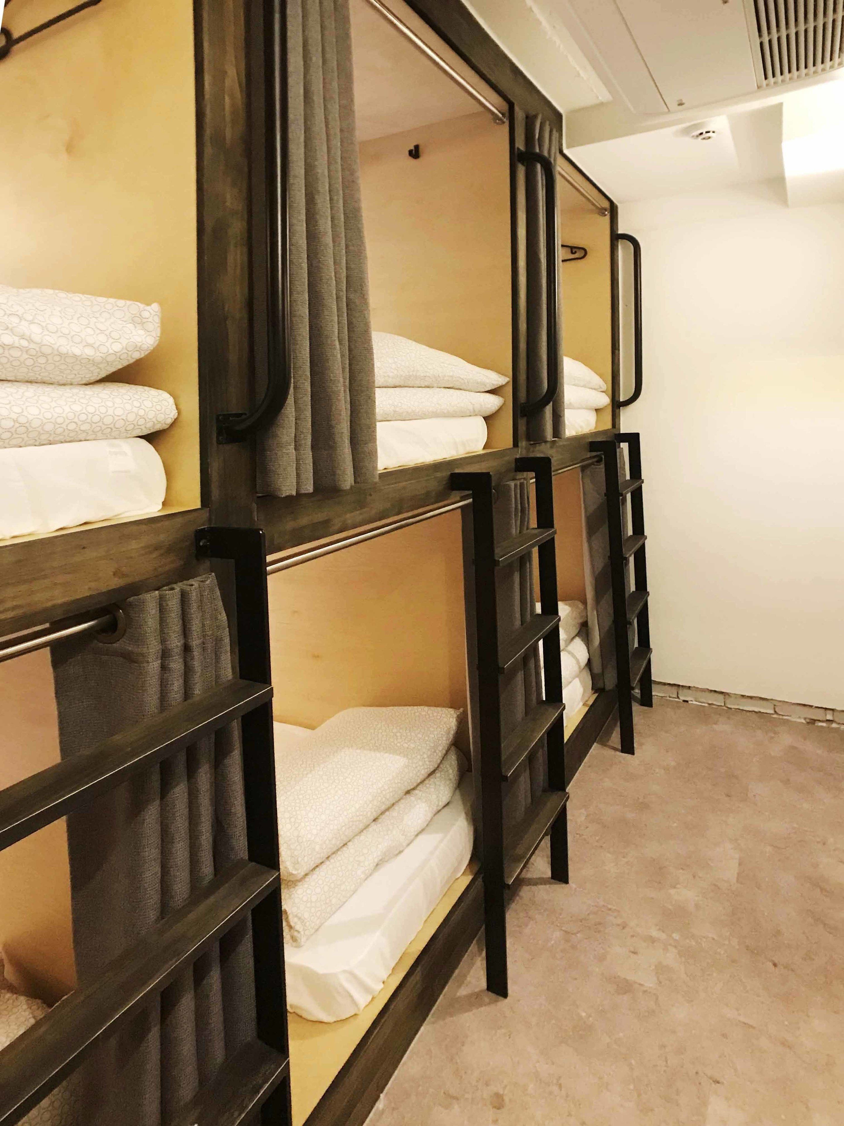 Bunk beds with towels, a mirror, and a ventilation system.