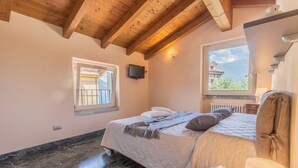 Une chambre à coucher avec un lit, une fenêtre, une télévision et une lampe.