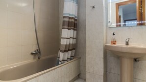 A bathroom with a bathtub, a shower, and a sink. - 4 Bed-Sleeps 6-Garden-Balcony-Pets (Alcalá de Henares)