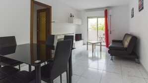 A modern living room with a dining area, a sofa, and a sliding glass door to a balcony. - 4 Bed-Sleeps 6-Garden-Balcony-Pets (Alcalá de Henares)
