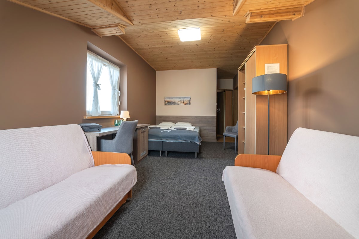 A cozy room with two single beds, a desk, and a chair.