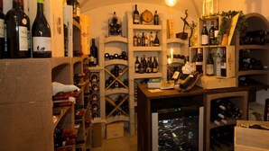 Una bodega con estantes llenos de botellas de vino, una botellera y un enfriador de vino.