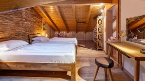 Una camera da letto mansardata accogliente con due letti, una scrivania e una sedia.
