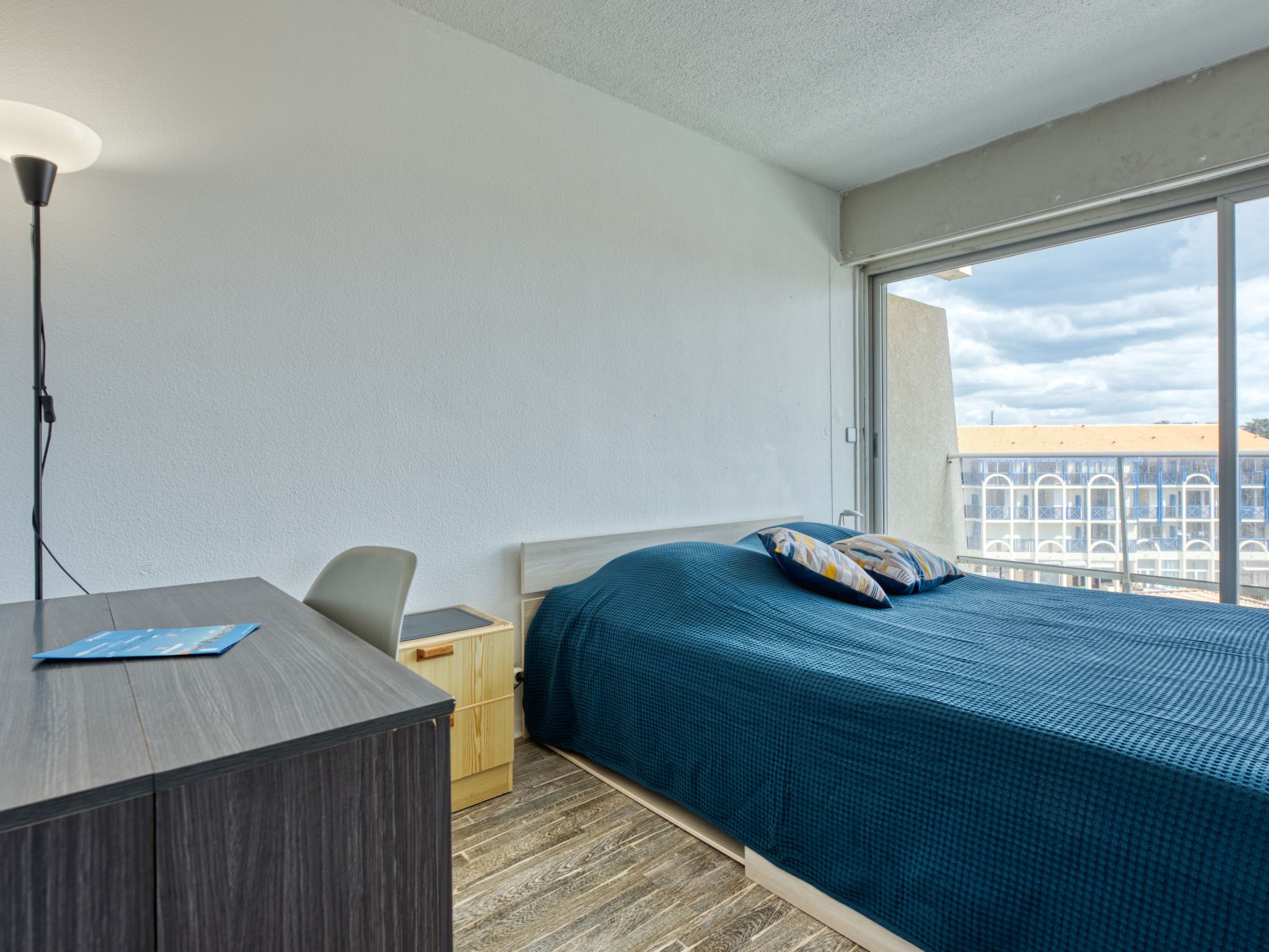 Una habitación de hotel con una cama, un escritorio y una silla.