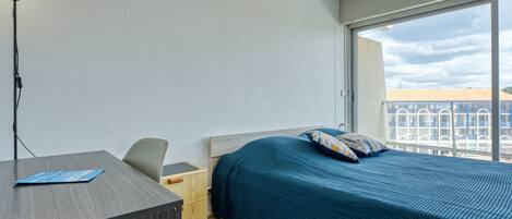 Una habitación de hotel con una cama, un escritorio y una silla.