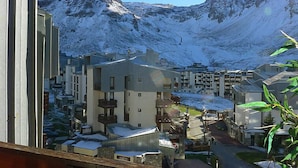 Ein Wohngebiet mit modernen Gebäuden, blauem Himmel und schneebedeckten Bergen im Hintergrund.