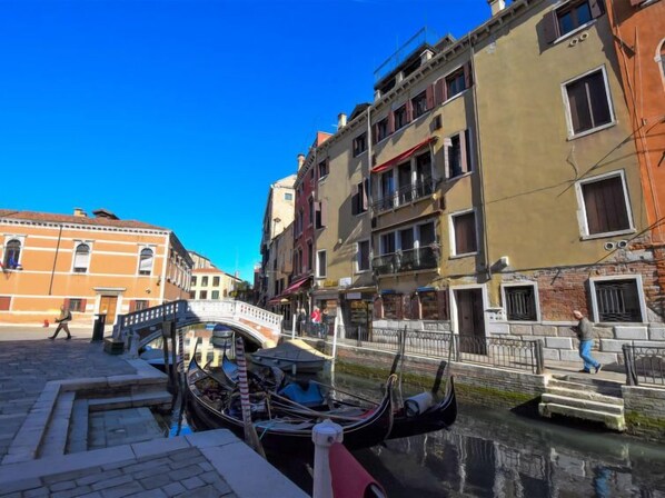 A canal with gondolas, a bridge, and historic buildings along the water.