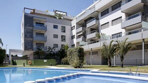 Een modern appartementencomplex met een zwembad.